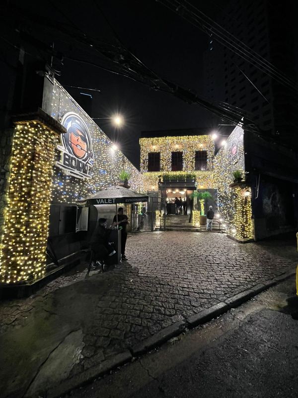 Fachada de restaurante coberta de luzes douradas à noite