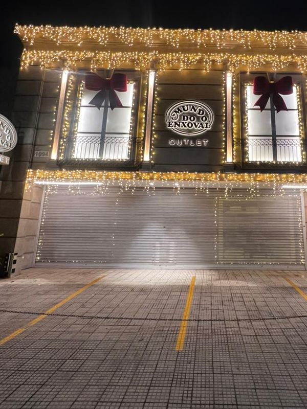 Fachada de outlet com cascatas de luz e laços nas janelas
