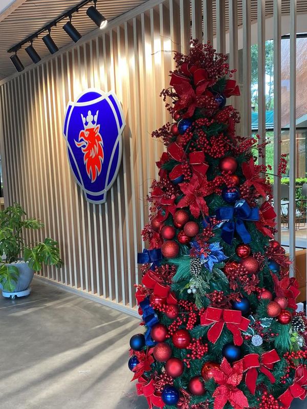 Árvore de Natal em vermelho e azul na recepção de uma montadora