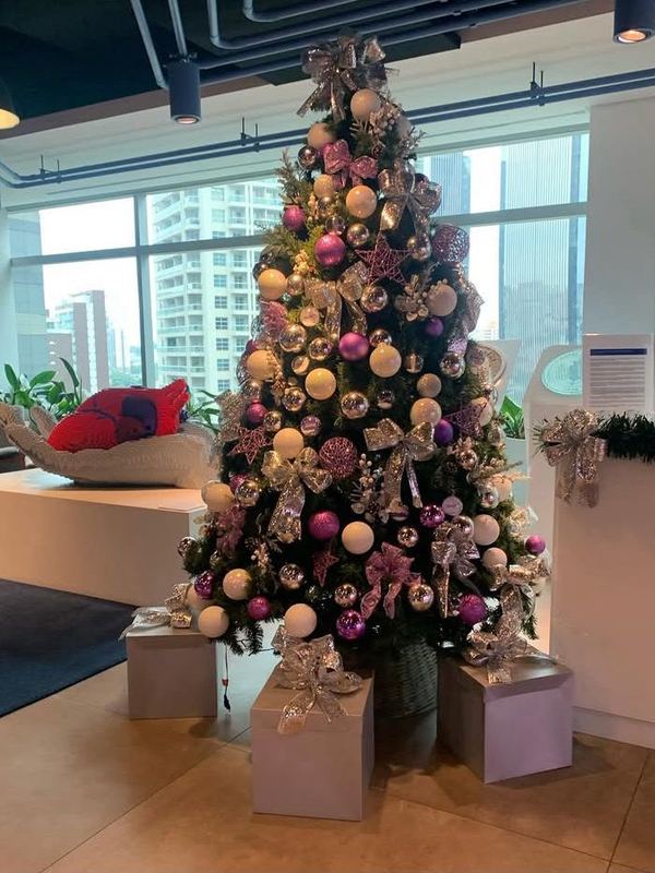 Árvore em rosa e prata em andar corporativo com vista para a cidade