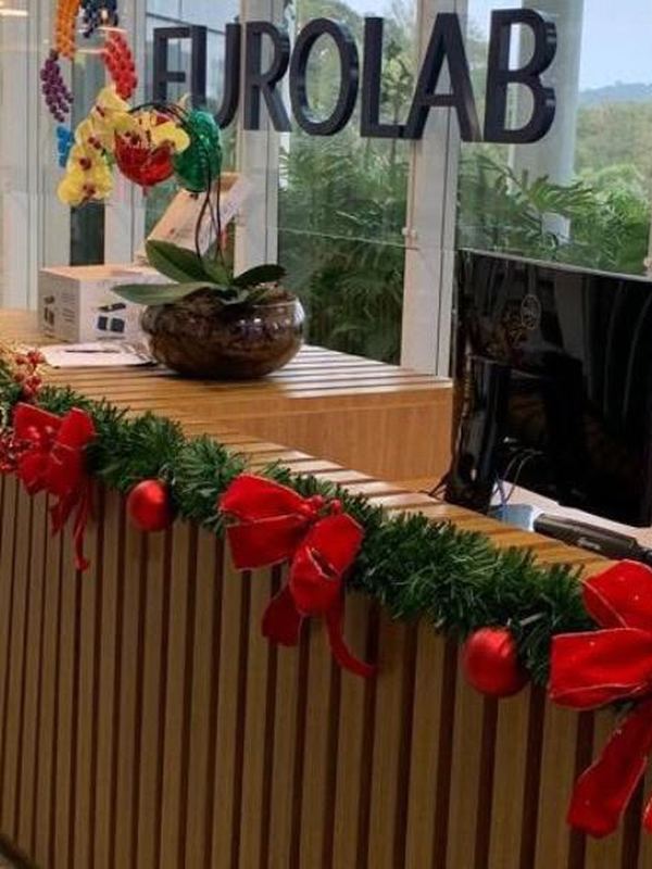 Guirlanda e festão em vermelho sobre o balcão de recepção de uma empresa