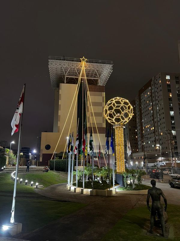 Fachada de edifício empresarial com árvore de luz e esfera iluminada