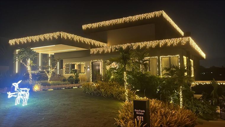 Residência em condomínio com cascatas de luz e jardim iluminado